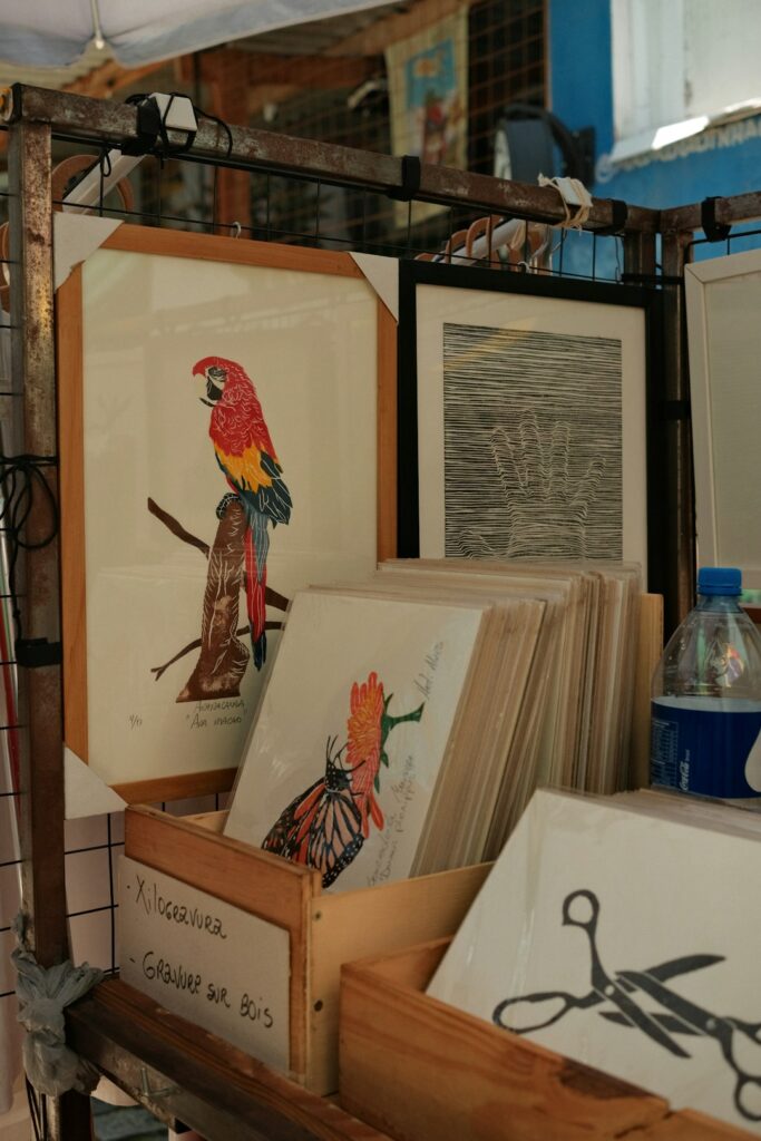 Collector examines a framed art print beside archival paper, mat board, and protective glazing.