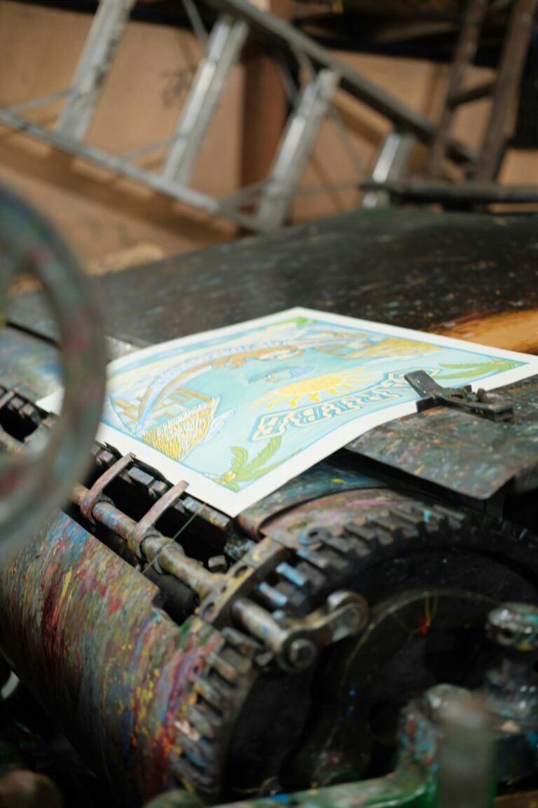 A person closely inspecting a textured art print on thick paper in natural light.